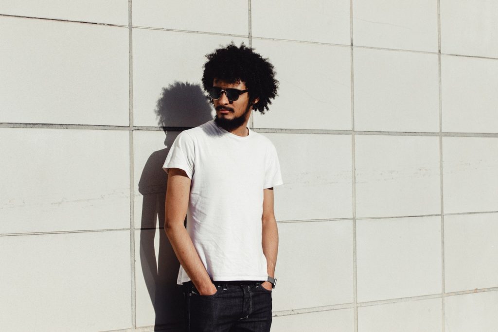 Jeune homme en tenue décontractée vêtu d'un t-shirt blanc et d'un pantalon en jean